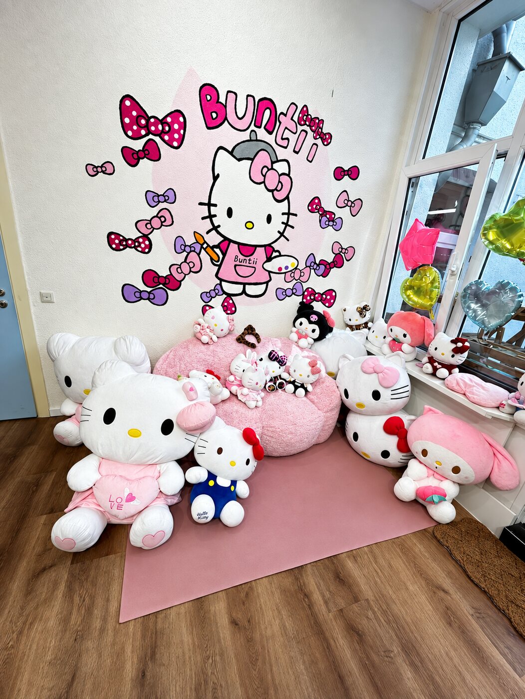 Hello-Kitty-Ecke mit handgemaltem Wandbild, rosa Sitzsack und riesigen Plüschtieren